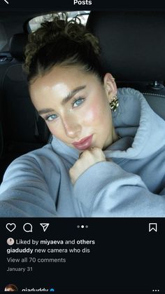 a woman sitting in the back seat of a car with her hand on her chin