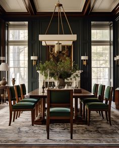 a dining room with green chairs and a chandelier hanging over the wooden table