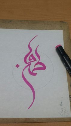 a pen is sitting on top of a piece of paper that has been drawn with pink ink