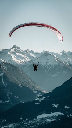 a person is para sailing in the mountains