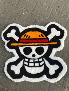 a black and white patch with a skull wearing a yellow hat on it's head