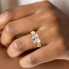 a woman's hand with a yellow and white diamond ring on her left hand