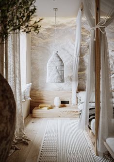 a bedroom with white walls and wood flooring next to a bed covered in mosquito netting