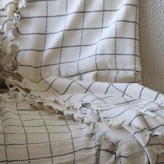 an unmade bed with a white and black checkered blanket on top of it