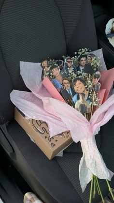 a bouquet of flowers sitting in the back seat of a car with pictures on it