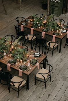 a table set up with place settings and greenery on it for an outdoor dinner