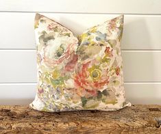 a floral pillow sitting on top of a wooden bench