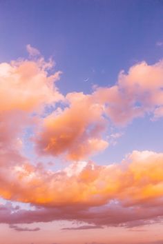 an airplane is flying in the sky at sunset