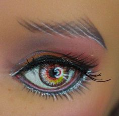 a woman's eye with long eyelashes and bright colored eyeshadow on her face