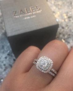 a close up of a person's hand with a diamond ring on their finger