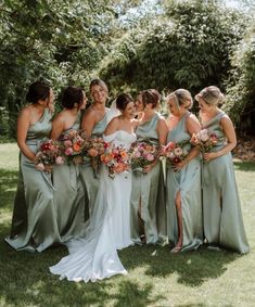 a group of women standing next to each other on top of a lush green field