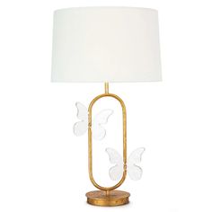 a gold lamp with white butterflies on the base and a white linen shade over it