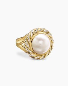 a pearl and diamond ring in yellow gold with white diamonds on the sides, set against a white background