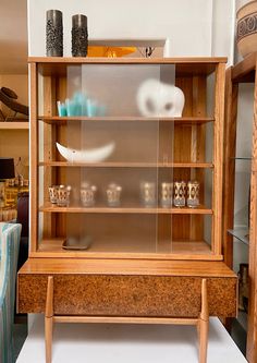 a wooden cabinet with glass shelves on top