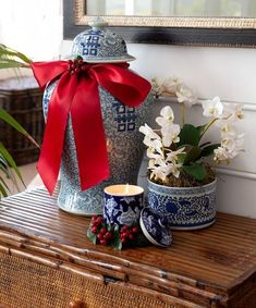 a blue and white vase sitting on top of a wooden table next to a candle