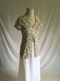 a woman's dress on a mannequin with white fabric and brown print