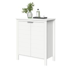 a white cabinet with a plant and bottles on it's top, against a white background