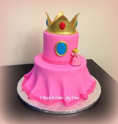 a pink cake with a gold crown on top