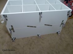 a large white cabinet with several compartments on the top and bottom, sitting on carpeted flooring