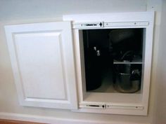 an open cabinet with pots and pans in it