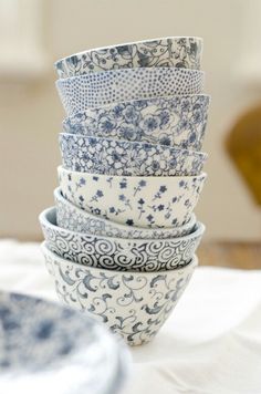 a stack of blue and white bowls sitting on top of a table