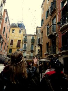 some people are standing in the middle of an alley way and one person is waving