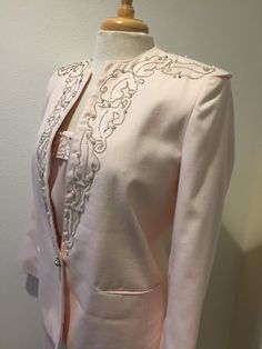 "Light Pink Beaded Detail 3 piece Special Occasion Designer Suit by Della Roufogali ladies size 8 D*E*S*C*R*I*P*T*I*O*N Jacket; Gorgeous 3 piece suit has a lot to love. Jacket has stunning silver, beads, pearls and rhinestones, exclusive of decoration on shoulders, upper back, and going down front sides. More features are; Stunning single & large rhinestone with pearl button for closure, with smaller but matching buttons at end of arms sleeves... Fully lined, fabric content is 65% Polyester Elegant Fitted Embellished Set, Spring Embellished Fitted Sets, Fitted Evening Sets With Rhinestones, Elegant Fitted Set With Rhinestones, Elegant Fitted Sets With Rhinestones, Elegant Beaded Festive Sets, Elegant Beaded Sets For Festive Occasions, Elegant Beaded Sets For Festive Season, Fitted Embroidered Evening Sets