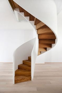 a spiral staircase with wooden steps in a white room