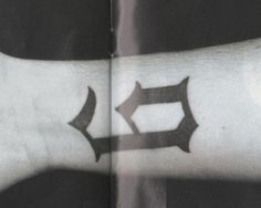 a person's arm with a cross tattoo on it