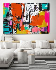 a living room with white couches and colorful paintings on the wall