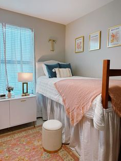 a white bed sitting next to a window in a bedroom on top of a rug