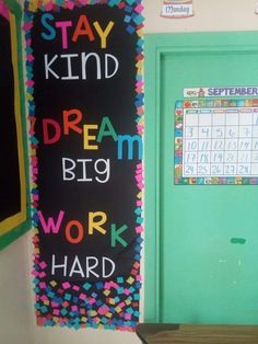 a chalkboard with words written on it in front of a classroom door that says stay kind dream work hard