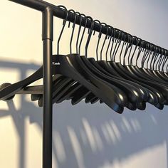 a bunch of black clothes hangers on a wall