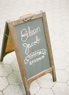 a chalkboard sign sitting on top of a sidewalk