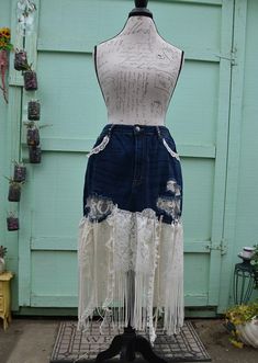 a mannequin with white lace and fringes on it's sides, standing in front of a blue door