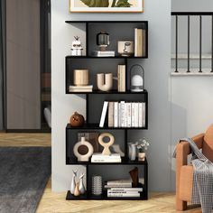 a room with a chair, bookshelf and pictures on the wall