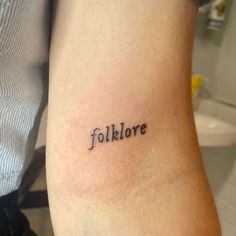 a tattoo with the word folklore written in cursive font on someone's arm