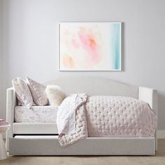 a white daybed with pillows and blankets on it