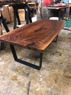 a wooden table sitting on top of a floor next to other woodworking tools and equipment