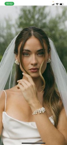 a woman wearing a wedding veil and diamond bracelets