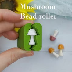 someone is holding a mushroom bead roller in front of some mushrooms and sunflowers