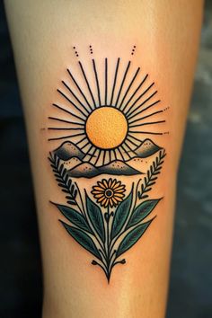 a sun and flowers tattoo design on the right calf leg, with mountains in the background