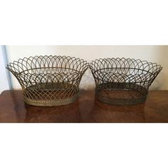 two metal baskets sitting on top of a wooden table