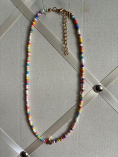 This Choker is made 8.0mm glass beads with a heart charm in the center, Strung them in beading wire and has plated 2 inches extender chain. It measures 15 inches long. Ready to ship in 3 days. Handmade. Multicolor Letter Beads Choker, Multicolor Letter Beads Choker With Round Beads, Multicolor Choker With Round Letter Beads, White Heart Beads Choker Necklace, White Choker Necklace With Heart Beads, Colorful Heart Beads Necklaces For Festivals, Colorful Festival Necklaces With Heart Beads, Multicolor Heart Beads Necklaces For Jewelry Making, Colorful Heart Beads Necklace For Festivals