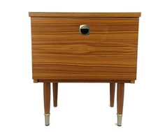 a wooden cabinet with two legs and a drawer on one side, it has a hole in the middle