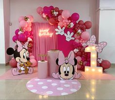 a minnie mouse themed birthday party with balloons and decorations on the floor, including candles