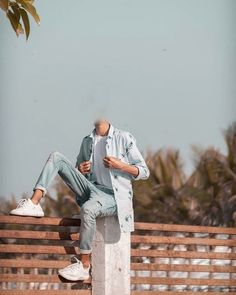 a man sitting on top of a wooden bench