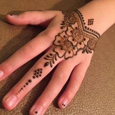 a woman's hand with henna tattoos on it