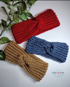 three crocheted headbands on top of each other next to a plant