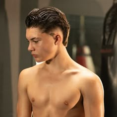 a shirtless young man standing in front of a mirror